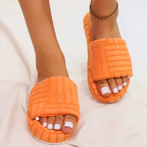 Detail view of orange embossed plush slides with thick platform soles