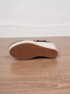 Detalle de la suela de una elegante sandalia de cuña negra para mujer con cuerda