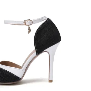 Close-up of denim and white leather stiletto heels with an elegant ankle strap.