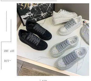 Side view of luxury rhinestone platform sneakers in black and silver finishes