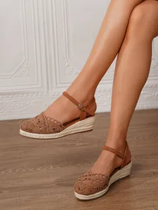 Detalle de sandalias de cuña con ganchillo marrón para mujer con correa al tobillo