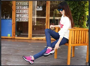 Modelo asiática con zapatillas deportivas rosas con cámara de aire en una terraza