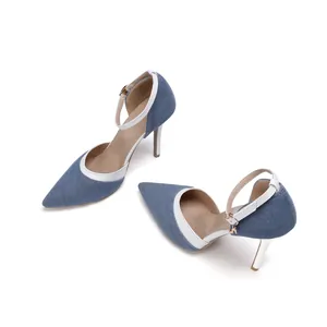 Detailed view of denim pointed-toe pumps with white ankle straps and stiletto heels.