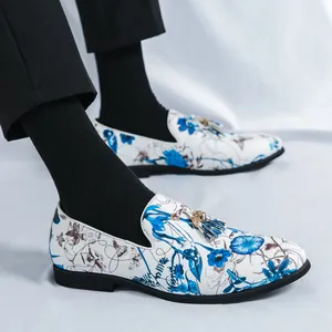 Men's stylish white loafers featuring elegant blue floral print and metal tassel accents.