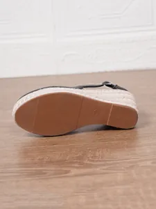 Détail rapproché de sandales compensées avec semelle antidérapante et bords tressés