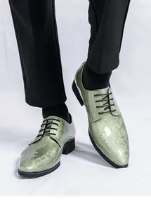 Détail des chaussures d'homme pointues en cuir verni vert sauge à motifs floraux