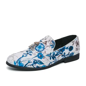 Men's stylish white floral print loafers with tassel detail shown from side view