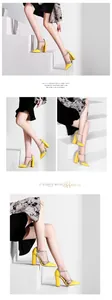 Detailansicht gelbe Pumps mit Blockabsatz und Strass-T-Riemen auf einer weißen Treppe.