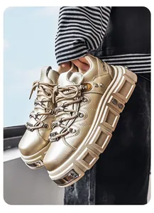 Primo piano di sneakers platform punk metallizzate oro con vistosi dettagli di borchie.