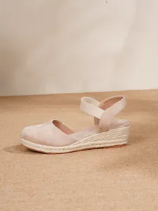 Vista lateral de sandalias de cuña tipo alpargata beige con correas elásticas al tobillo