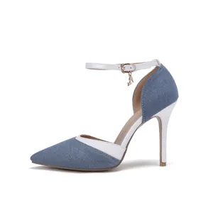 Side view of pointed toe denim stiletto pumps with white trim and delicate ankle strap