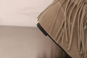 Detailaufnahme der Wildlederfransen und der Keilabsatzform dieser khakifarbenen Damenstiefel