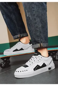Close-up detail of trendy white studded sneakers with meander pattern and black accents