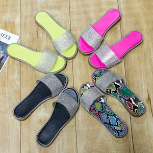 Detailweergave van fonkelende strass platte sandalen in vier levendige kleuren en patronen.