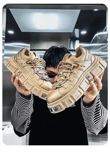 Primo piano di sneakers platform punk dorate con borchie in metallo pesante e suole spesse