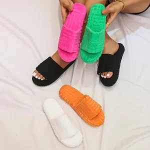 Close-up of colorful fuzzy platform slides with embossed patterns in multiple bright shades.