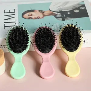 Close-up view of three colorful mini boar bristle brushes for scalp massage and hair detangling