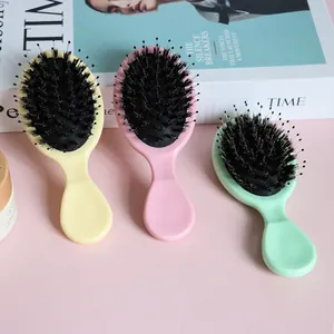 Detail shot of three colorful boar bristle detangling cushion hairbrushes on pink background