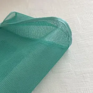 Macro detail showing the light green mesh fabric texture and reinforced edge of tote bag