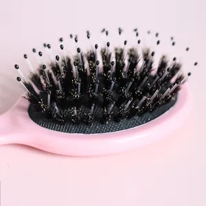 Detailed view of pink boar bristle hairbrush for detangling and gentle scalp massage