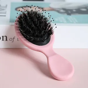 Pink mini boar bristle hairbrush for detangling and scalp massage in portable travel size
