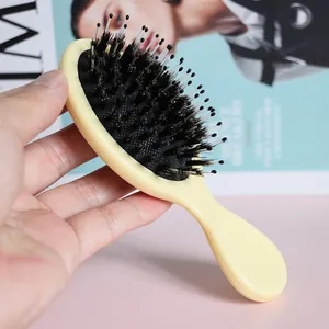 Small boar bristle air cushion hairbrush for detangling and scalp massage in light yellow