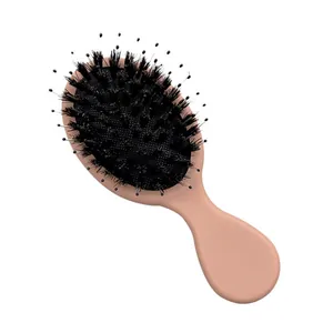 Mini boar bristle hairbrush with detangling nylon pins and nude pink handle for massage.