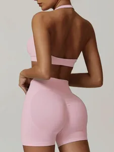 Vista dettagliata di un set da yoga rosa con reggiseno allacciato al collo e pantaloncini.
