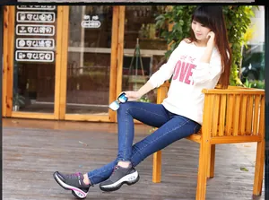 Modelo asiática luciendo zapatillas casuales con suela gruesa y cámara de aire al aire libre