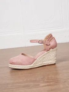 Dettaglio del sandalo con zeppa in pelle scamosciata rosa e suola in corda intrecciata