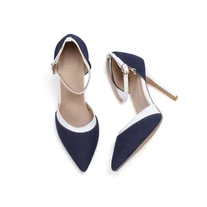 Detail of pointed-toe denim stiletto pumps with white leather trim and ankle straps