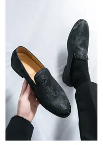 Nahaufnahme von schwarzen Herren-Loafers mit eleganter Blumenmuster-Prägung für Abendmode.