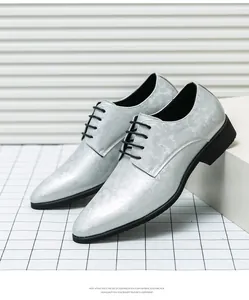 Détail de chaussures habillées argentées pour hommes avec lacets noirs et semelle en EVA.