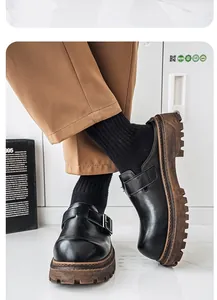 Detalle de mocasines de cuero negro para hombre con suela de plataforma y hebilla de metal