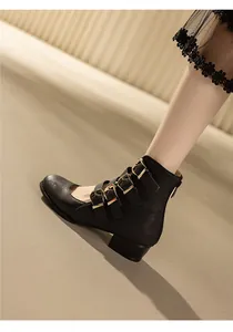 Close-up of retro black Mary Jane Roman ankle boots with triple buckle straps