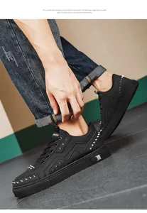 Macro detail of black men's casual low-top sneakers featuring stylish silver spike rivets