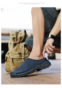 Close-up detail of navy blue suede slip-on casual shoes for men worn on a wooden deck