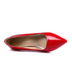 Close-up top view of elegant red patent leather pointed-toe pump shoes for women.