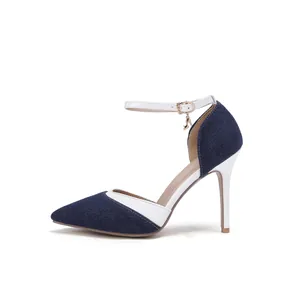 Side detail of denim and white leather pointed toe stiletto pumps with ankle strap.