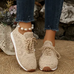 Close-up detail of beige lace-up walking shoes with elegant floral mesh pattern design