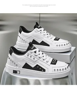 Macro view of stylish white men's sneakers featuring black accents and punk silver studs
