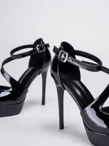 Detailansicht von schwarzen Lackleder-Plateau-High-Heels mit verstellbarem Knöchelriemen.