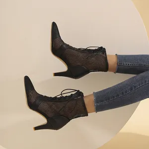 Dettaglio degli stivaletti a spillo in rete nera con elegante design stringato