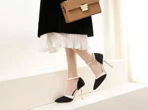 Side view detail of black and white denim pointed toe stilettos with ankle strap