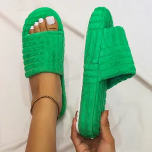 Detailed view of green embossed plush one-band slippers featuring a thick comfortable white sole