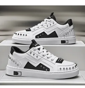 Detailed view of white luxury men's sneakers with black accents and silver rivets