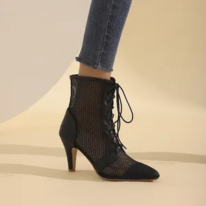 Primo piano di stivaletti stringati in rete nera con un elegante design a punta