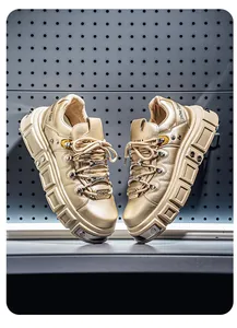 Primo piano di sneakers platform punk dorate con dettagli in borchie e finitura metallica di lusso