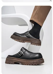 Vista lateral de zuecos de cuero negro para hombre con suela de goma gruesa.