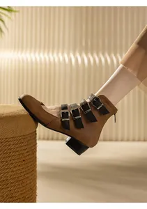 Side detail of brown retro chunky heel Mary Jane boots with four black buckle straps.